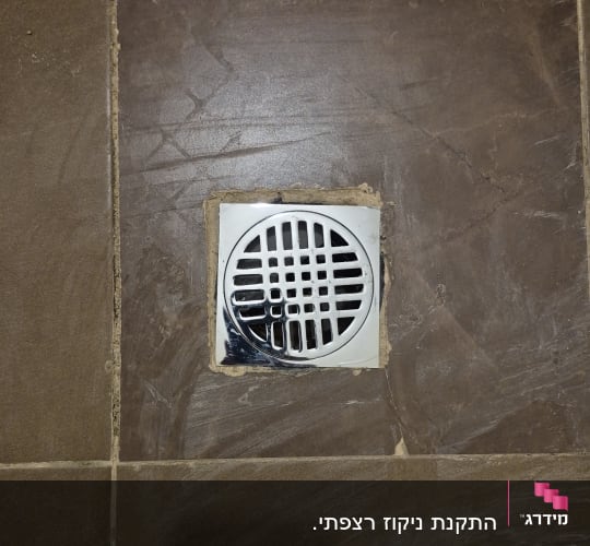 רצפת אריחים עם ניקוז מותקן במרכז